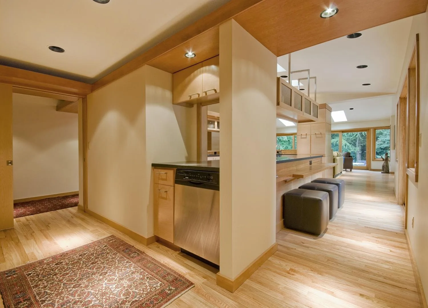 Open kitchen and living space with custom wood cabinetry by KDJ Cabinet Design