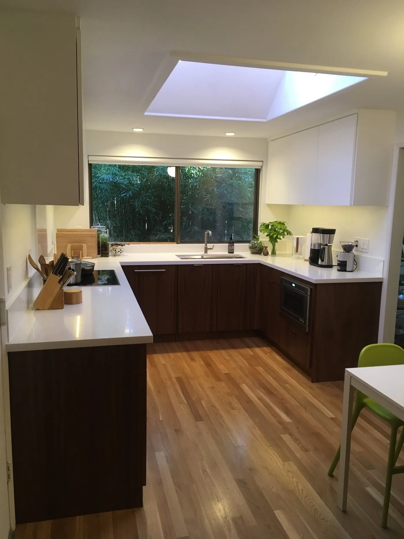 Kitchen with dark wood lower cabinets and white uppers by KDJ