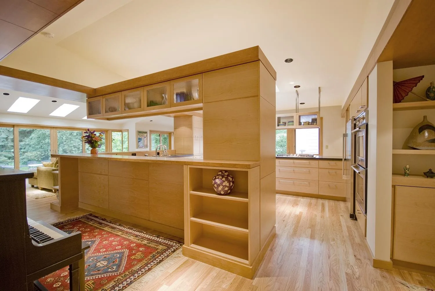 Bright kitchen with custom light wood cabinetry and island by KDJ Cabinet Design